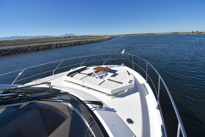 Slide: The Image of The image shows the bow of a 2019 Cruisers Yachts 50 Cantius on calm waters. - 38