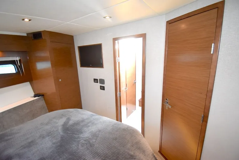 Slide: The Image of Interior of a 2019 Cruisers Yachts 50 Cantius with wood doors and a TV. - 25