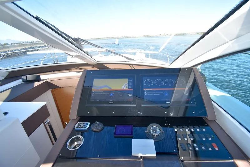 Slide: The Image of The image shows the cockpit of a 2019 Cruisers Yachts 50 Cantius with modern navigation systems. - 17