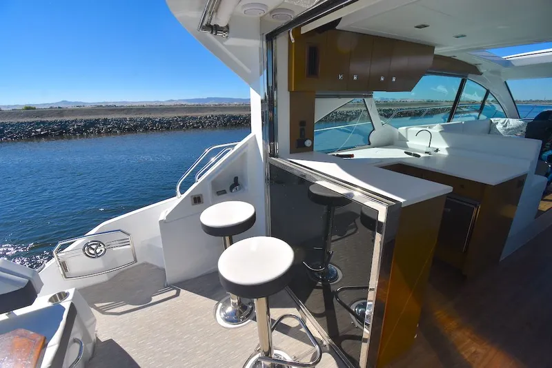 Slide: The Image of The 2019 Cruisers Yachts 50 Cantius features a modern kitchen with bar stools and a water view. - 10