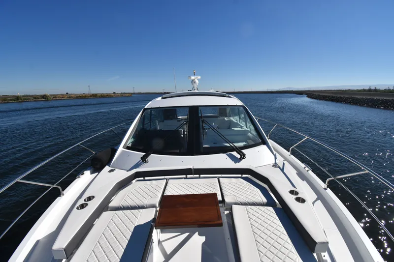 Slide: The Image of The image shows a 2019 Cruisers Yachts 50 Cantius on the water. It features a sleek, modern design with a spacious foredeck and a clear view of the horizon. - 42