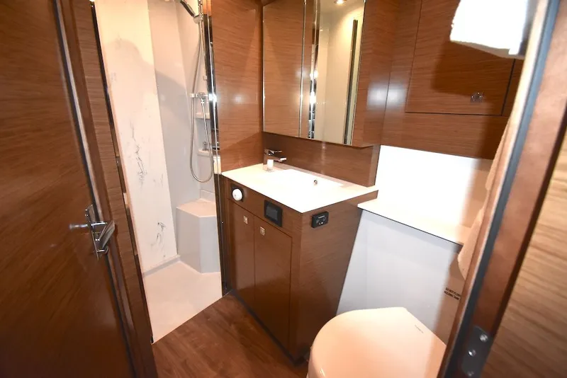 Slide: The Image of Bathroom with wood paneling, sink, toilet, and shower in a 2019 Cruisers Yachts 50 Cantius. - 27