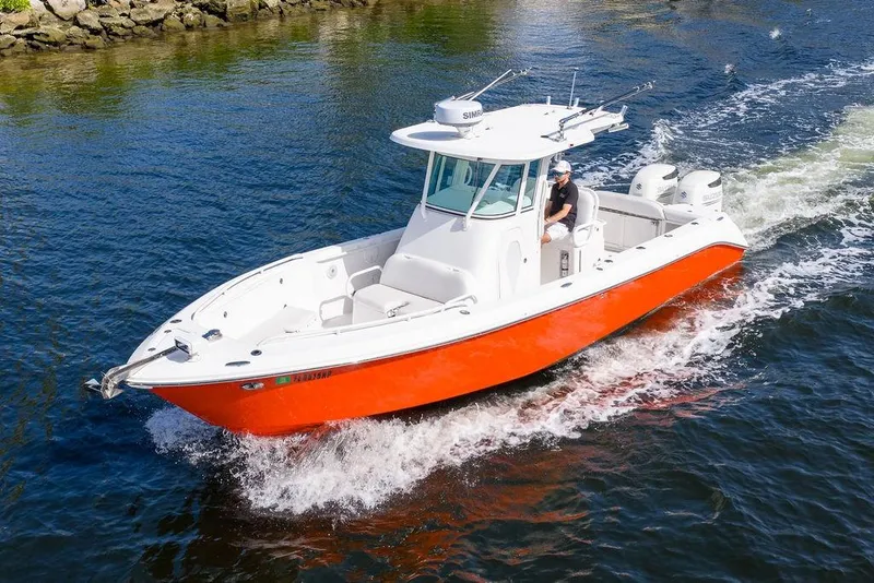 Slide: The Image of 2006 Everglades 290 Center Console boat cruising on water, vibrant orange hull. - 9