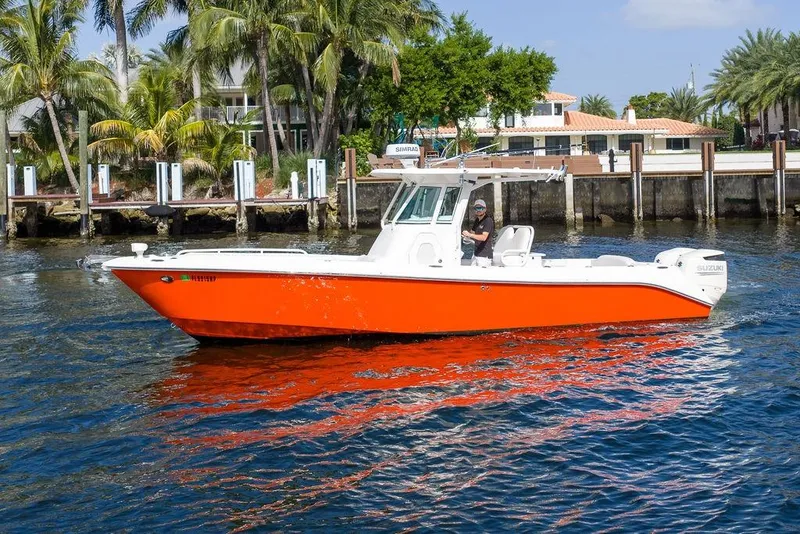 Slide: The Image of 2006 Everglades 290 Center Console boat on water, vibrant orange hull, palm trees background. - 5