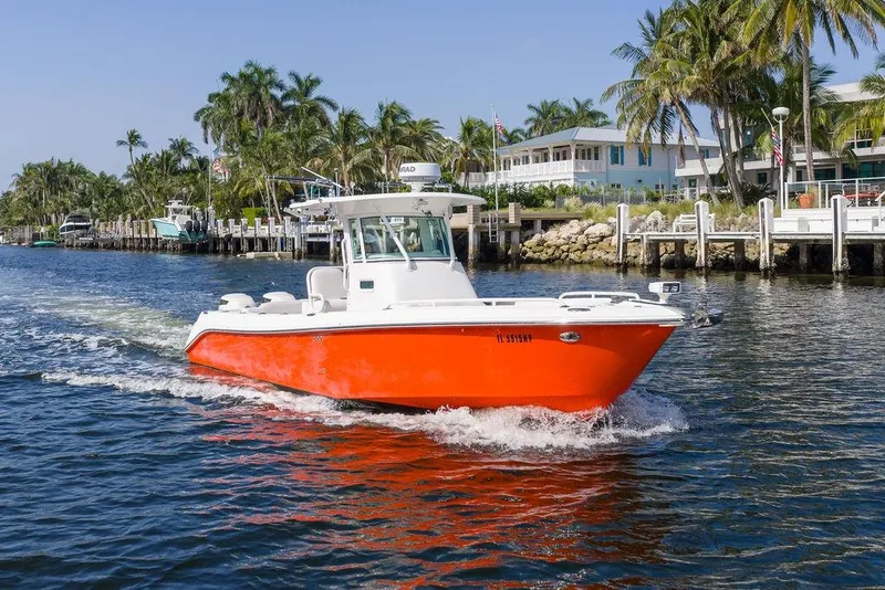 Slide: The Image of 2006 Everglades 290 Center Console boat cruising near waterfront homes and palm trees. - 1