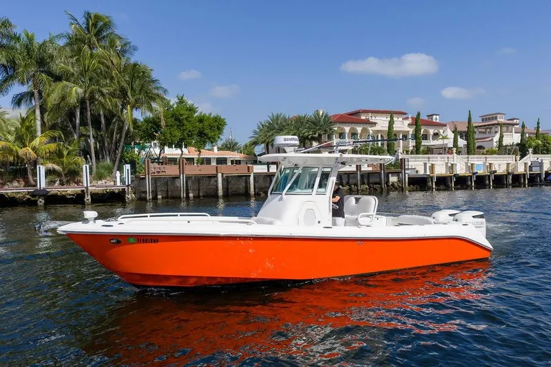 Slide: The Image of 2006 Everglades 290 Center Console boat on water, vibrant orange hull, palm trees in background. - 6