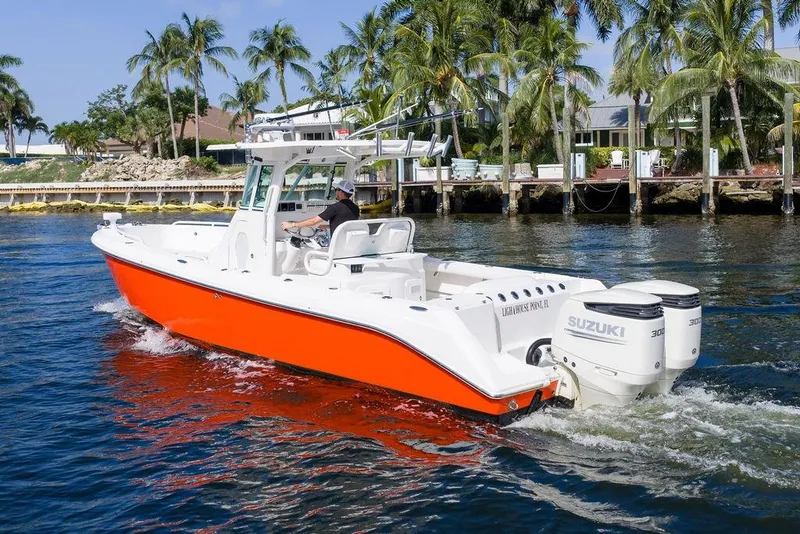 Slide: The Image of 2006 Everglades 290 Center Console boat cruising near palm-lined waterfront homes. - 7