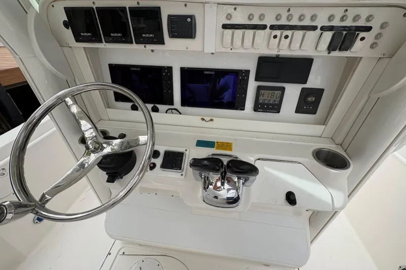 Slide: The Image of Control panel of a 2006 Everglades 290 Center Console boat with steering wheel and gauges. - 24