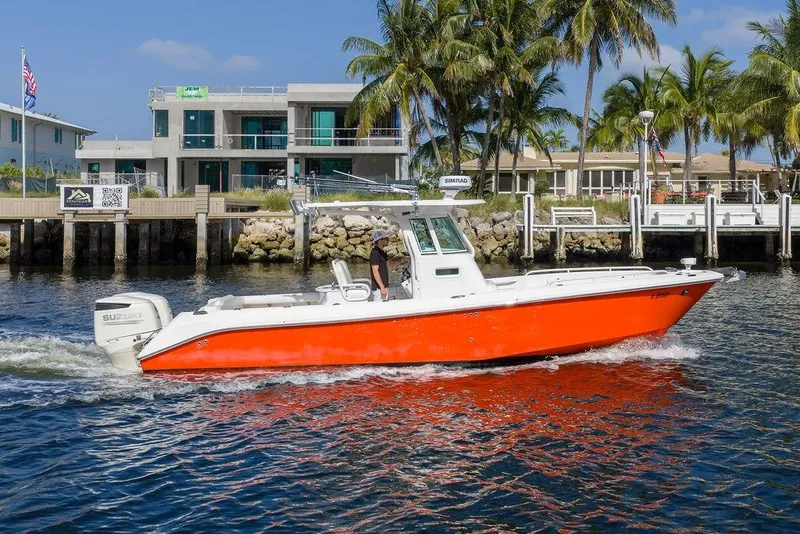 The Image of 2006 Everglades 290 Center Console boat cruising near waterfront homes and palm trees. - 0