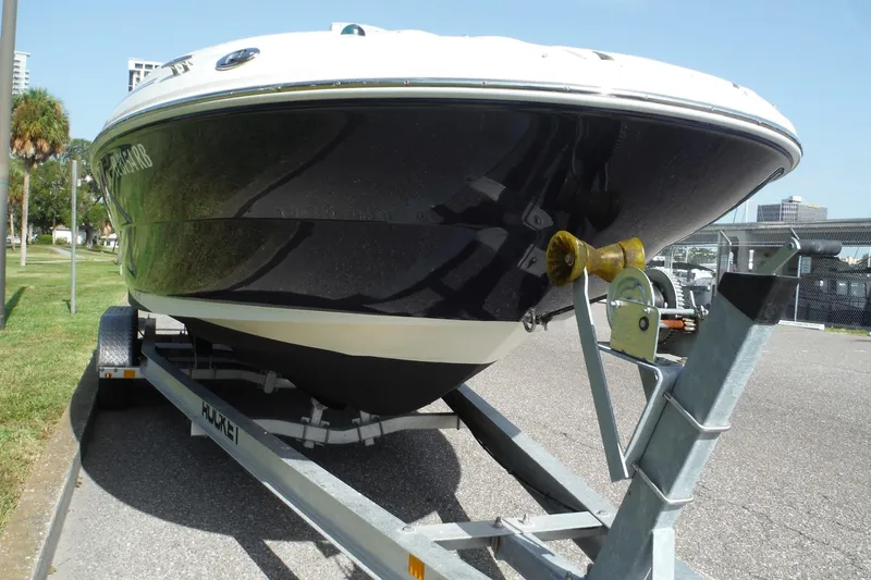 Slide: The Image of 2005 Sea Ray 240 Sundeck boat on trailer, parked outdoors. - 2