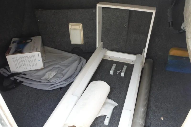 Slide: The Image of Storage compartment of a 2005 Sea Ray 240 Sundeck with various items inside. - 17
