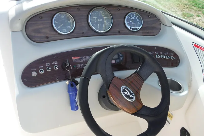 Slide: The Image of Dashboard of a 2005 Sea Ray 240 Sundeck boat with steering wheel and gauges. - 8
