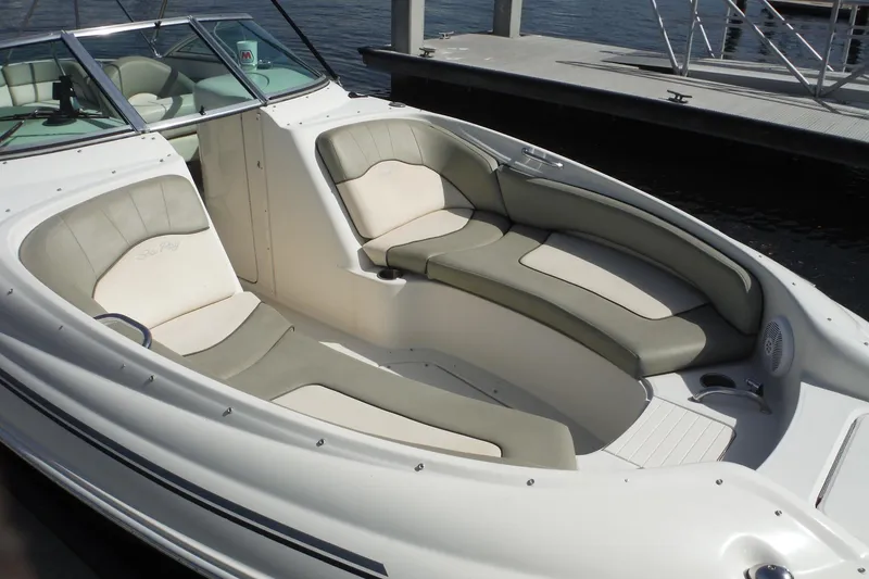Slide: The Image of 2005 Sea Ray 240 Sundeck boat with spacious seating, docked by the water. - 31