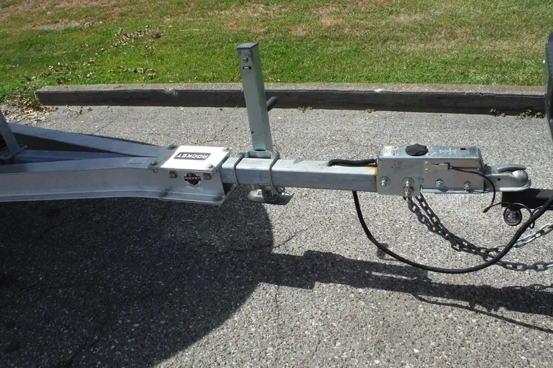 Slide: The Image of Trailer hitch for 2005 Sea Ray 240 Sundeck on pavement, featuring safety chains. - 39