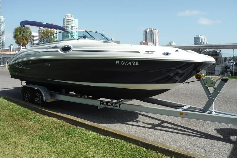 Slide: The Image of 2005 Sea Ray 240 Sundeck boat on trailer, urban background, sunny day. - 1