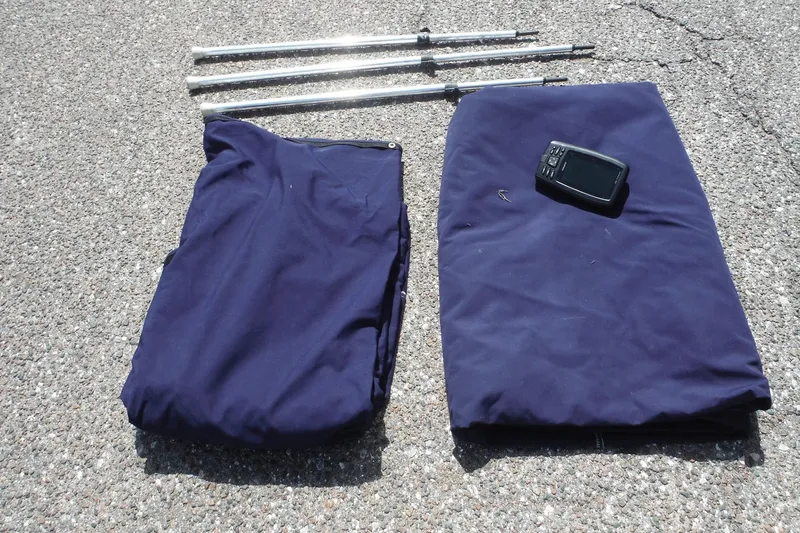 Slide: The Image of Folded blue covers, metal poles, and a device on pavement for 2005 Sea Ray 240 Sundeck. - 35