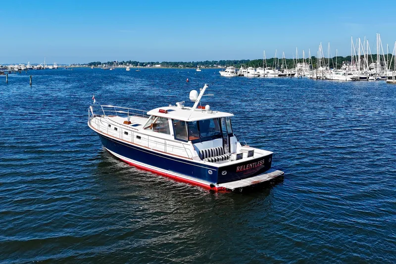 Slide: The Image of 2001 Grand Banks 49 Eastbay HX yacht cruising in a scenic marina setting. - 4