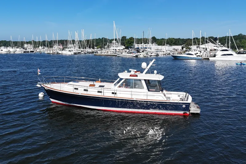 Slide: The Image of 2001 Grand Banks 49 Eastbay HX yacht on calm water near marina. - 2