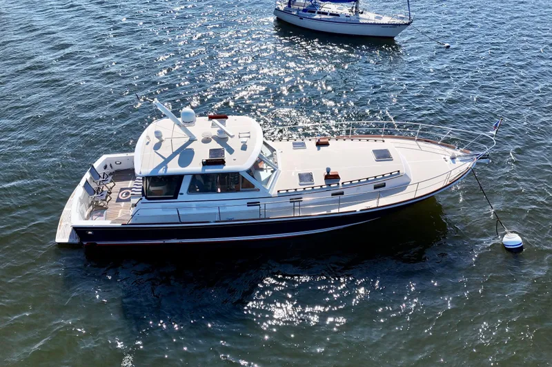 Slide: The Image of 2001 Grand Banks 49 Eastbay HX yacht on shimmering water, aerial view. - 9