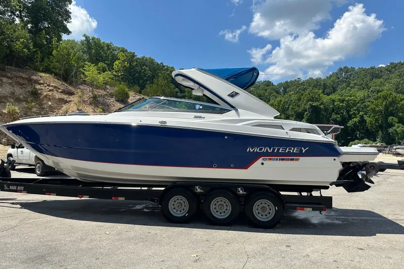 The Image of 2019 Monterey 328SS Super Sport boat on trailer, parked outdoors under a blue sky. - 1