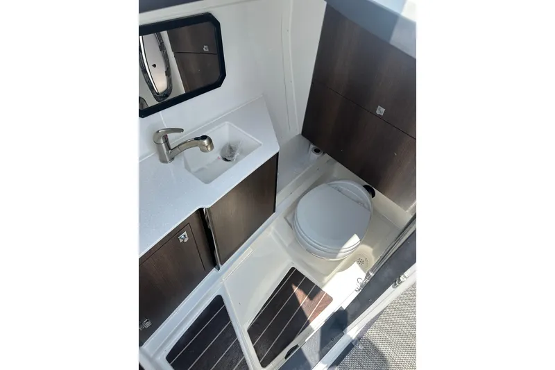 Slide: The Image of 2019 Monterey 328SS Super Sport boat bathroom with sink, toilet, and storage cabinets. - 14