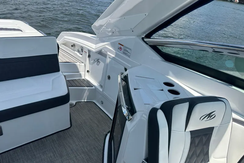 Slide: The Image of 2019 Monterey 328SS Super Sport boat interior with seating and cup holders on the water. - 10