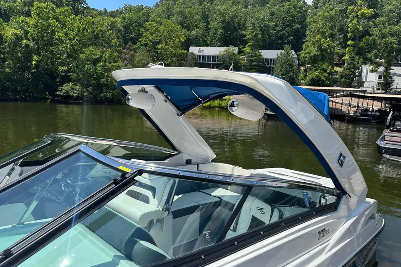 Slide: The Image of 2019 Monterey 328SS Super Sport boat docked on a serene lake with lush greenery. - 19