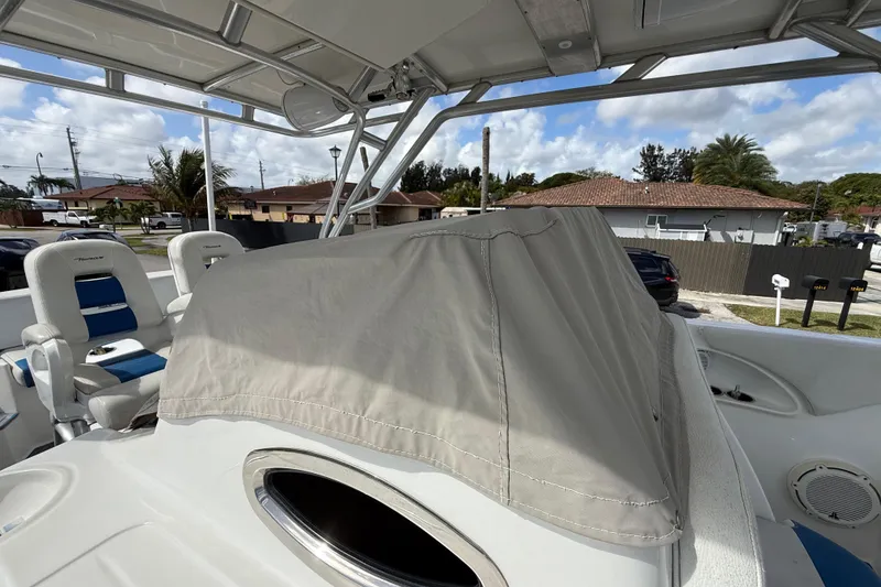 Slide: The Image of 2016 Extreme Boats XC38 with covered console, featuring blue and white seating, in a residential area. - 12