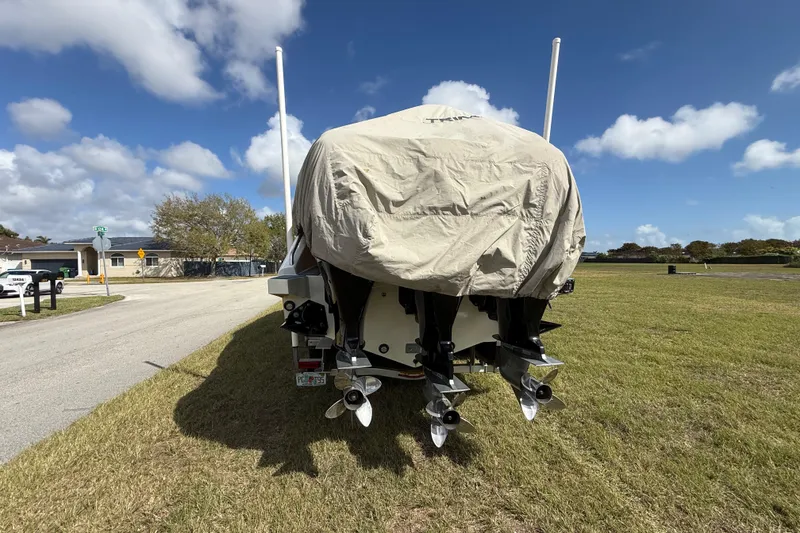 Slide: The Image of Covered 2016 Extreme Boats XC38 with dual outboard motors on grassy roadside. - 6