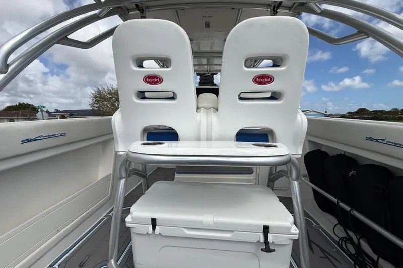 Slide: The Image of 2016 Extreme Boats XC38 interior with white seating and table under a blue sky. - 100