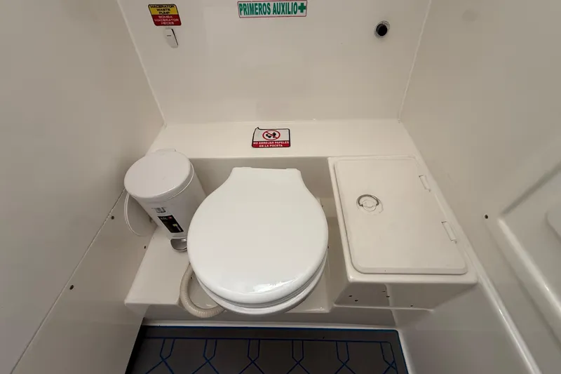 Slide: The Image of 2016 Extreme Boats XC38 marine toilet with storage compartment and safety signage. - 109
