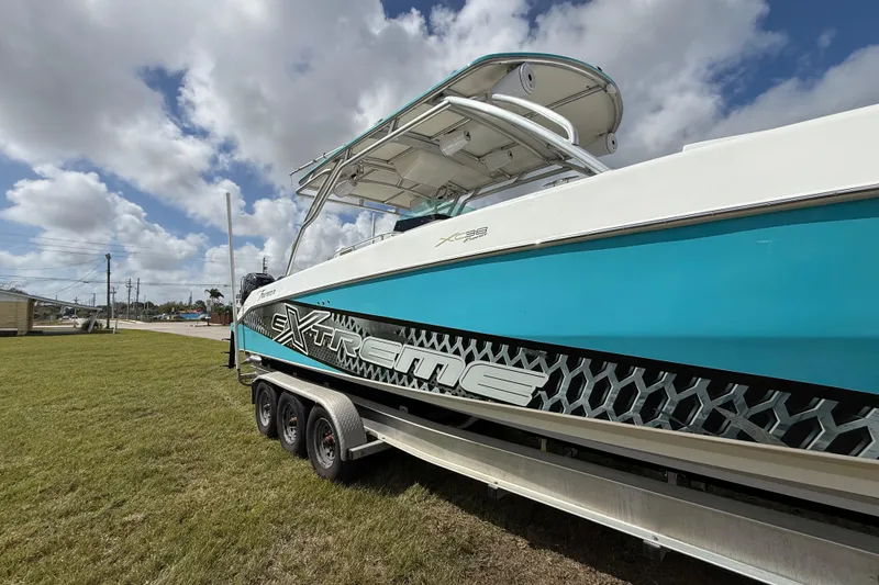 Slide: The Image of 2016 Extreme Boats XC38 on trailer, vibrant blue hull, under a partly cloudy sky. - 21