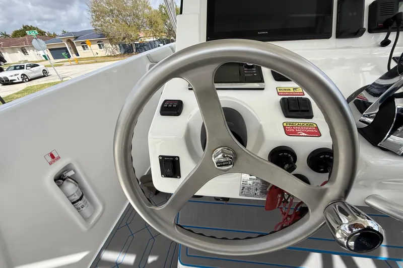 Slide: The Image of Steering wheel and controls of a 2016 Extreme Boats XC38, featuring a Garmin display. - 90