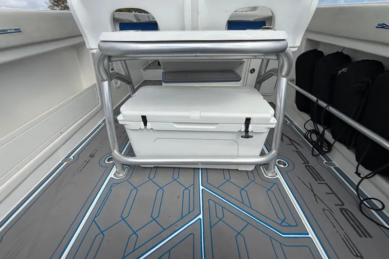 Slide: The Image of 2016 Extreme Boats XC38 interior with cooler and seating on patterned flooring. - 99