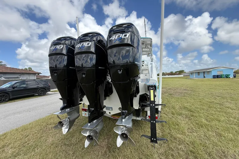 Slide: The Image of Triple Mercury 400R engines on a 2016 Extreme Boats XC38, parked on grass under a cloudy sky. - 28