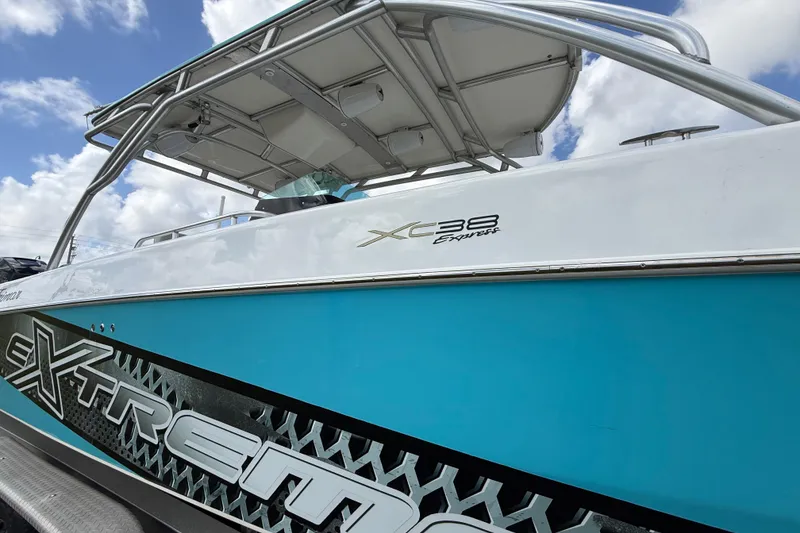 Slide: The Image of 2016 Extreme Boats XC38, blue and white exterior, under a cloudy sky. - 74