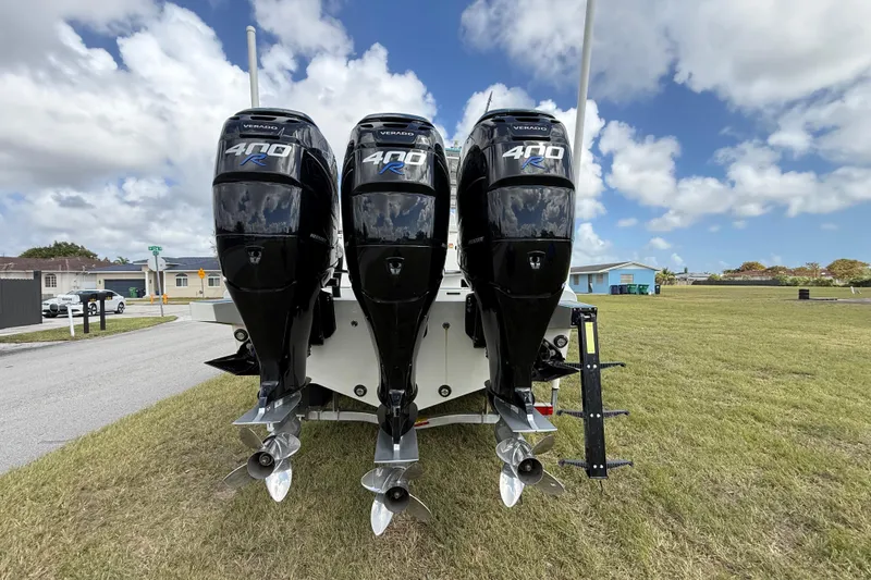 Slide: The Image of Four powerful outboard motors on a 2016 Extreme Boats XC38, parked on grass. - 29