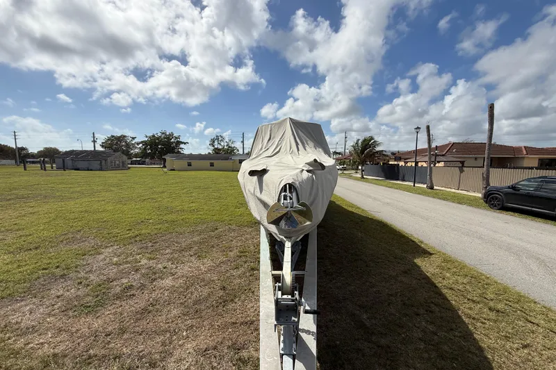 Slide: The Image of Covered 2016 Extreme Boats XC38 on trailer, parked on grassy area under a cloudy sky. - 8