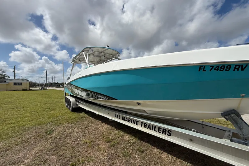 Slide: The Image of 2016 Extreme Boats XC38 on trailer, vibrant blue hull, under cloudy sky. - 17