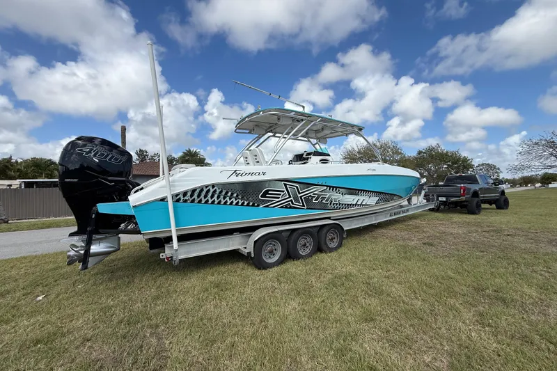 Slide: The Image of 2016 Extreme Boats XC38 on trailer, parked on grass under a cloudy sky. - 13