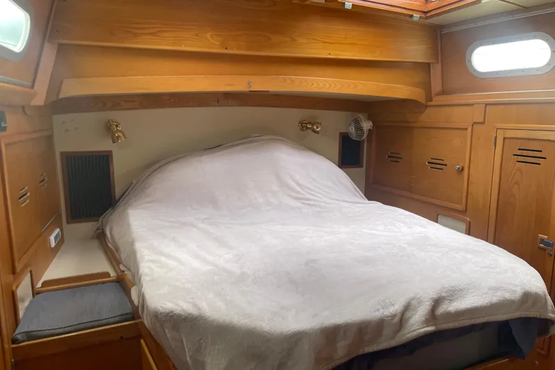 Slide: The Image of Cozy cabin interior of 1985 Hinckley Sou'wester 59 sailboat with wooden accents and bed. - 17