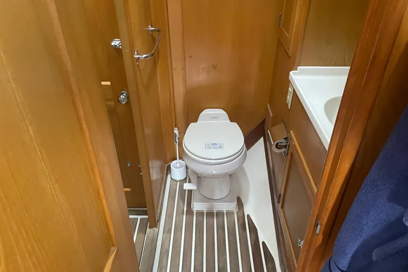 Slide: The Image of Hinckley Sou'wester 59 yacht bathroom, featuring wooden paneling and compact toilet, 1985 model. - 19