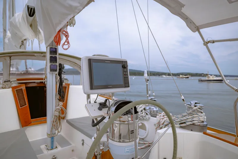 Slide: The Image of Cockpit of a 2001 Shannon 47/52 sailboat with navigation equipment and scenic harbor view. - 29
