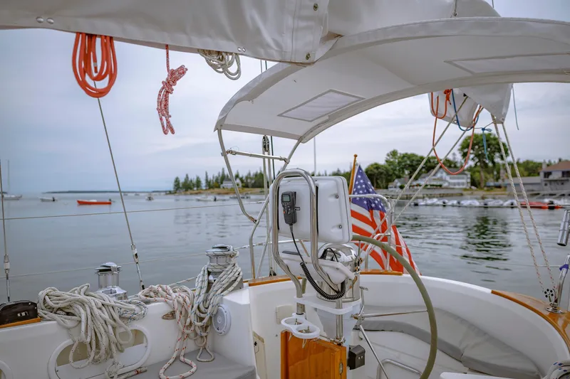 Slide: The Image of Cockpit of a 2001 Shannon 47/52 sailboat with American flag, docked in a serene harbor. - 27
