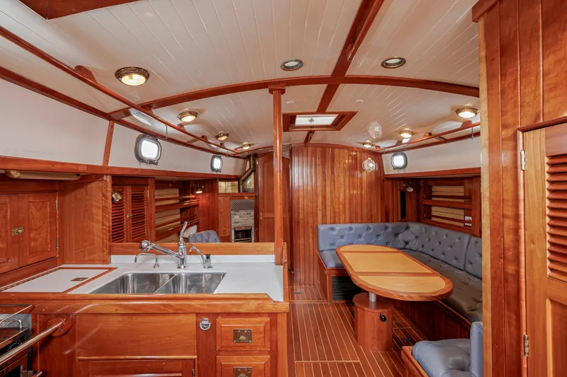 Slide: The Image of Luxurious 2001 Shannon 47/52 yacht interior with wood finish, featuring a kitchen and dining area. - 37