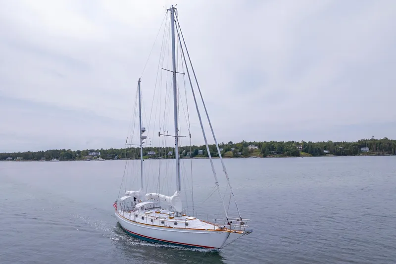 Slide: The Image of Sailing yacht Shannon 47/52, 2001 model, cruising on calm waters near a wooded shoreline. - 6