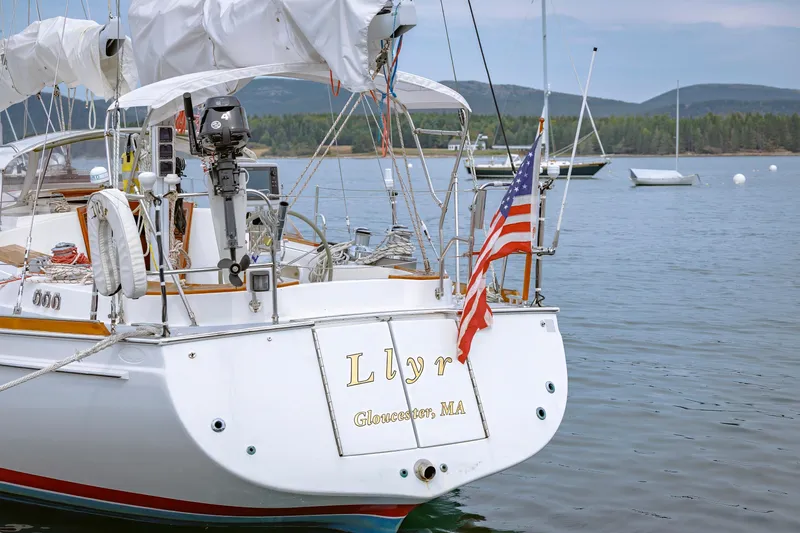 Slide: The Image of Sailboat "Llyr" docked in calm waters, displaying an American flag. - 18