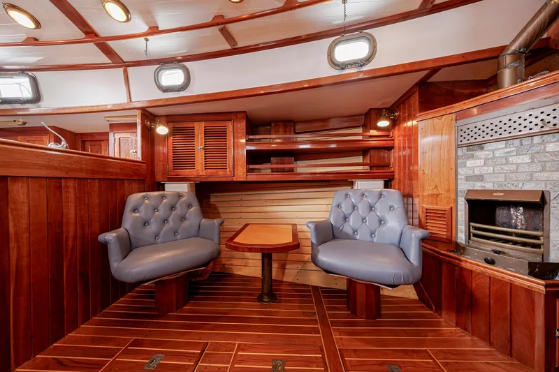 Slide: The Image of Luxurious wooden interior of a 2001 Shannon 47/52 yacht with plush seating and fireplace. - 52