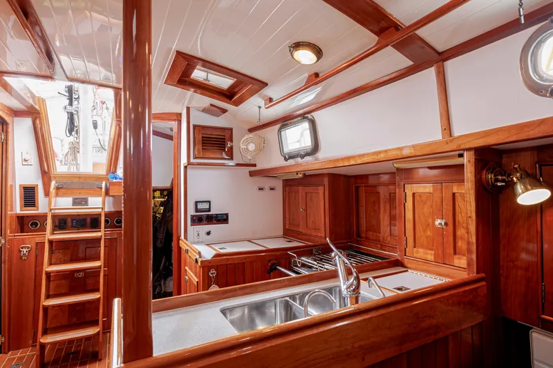 Slide: The Image of Luxurious wooden interior of a 2001 Shannon 47/52 yacht, featuring a well-equipped kitchen area. - 41