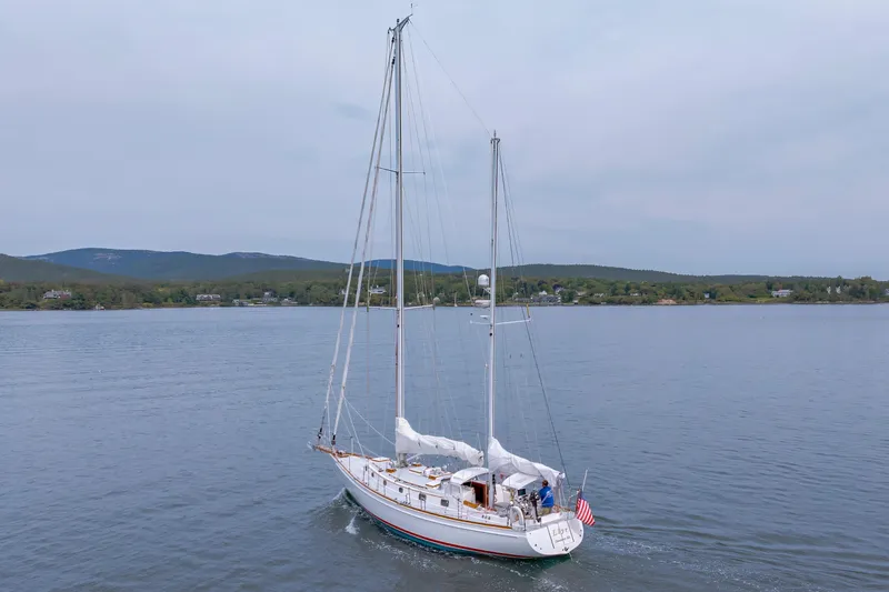 Slide: The Image of Sailboat Shannon 47/52 (2001) cruising on calm waters with scenic shoreline backdrop. - 7